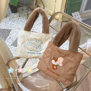 Quilted tote bags with cartoon animal embroidery and plush fur handles displayed on a chair