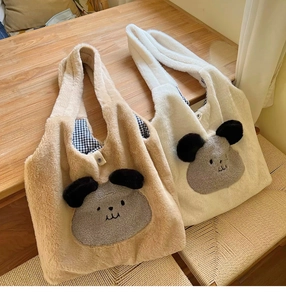 Detail of plush tote bags with puppy embroidery, magnetic closure, and blue gingham lining