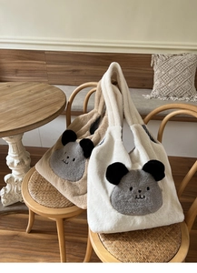 Detail of plush tote bags with cartoon animal patches and checkered lining on chairs