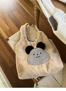 Detailed view of plush tote bag with cartoon bear design and blue checkered inner lining