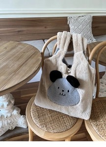 Close-up of fluffy faux rabbit fur tote bag featuring a cute cartoon animal and snap closure