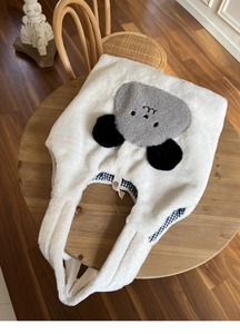Close-up of white plush tote bag showing cute animal patch and black checkered lining