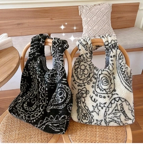 Detail of paisley pattern plush tote bags with soft fleece texture and plaid lining