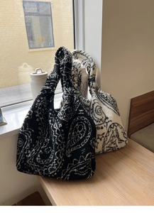 Detailed close-up of plush paisley tote bags in black and white fleece texture