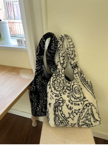 Detail of plush paisley lamb wool tote bags in black and white contrasting patterns