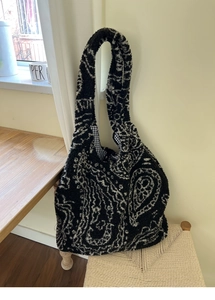 Detail of plush paisley tote bag with soft faux fur texture and black check lining
