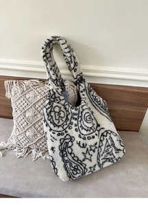 Detail of paisley pattern on white faux shearling tote bag with bohemian texture