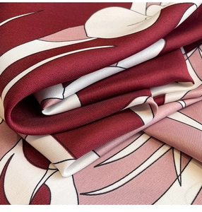 Detailed view of luxury twill silk scarf with burgundy floral print and smooth texture