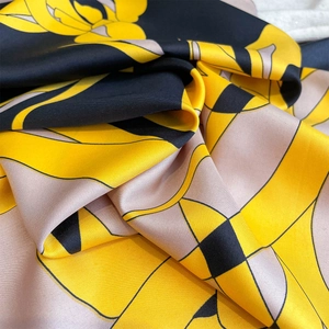 Macro detail of high-end silk scarf featuring abstract floral prints and twill texture