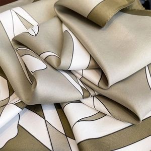 Macro view of green and white silk square scarf with twill weave texture and abstract pattern