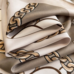 Vue détaillée du foulard en soie champagne avec motifs de chaînes et texture sergé
