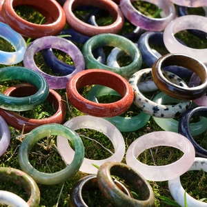Polished natural crystal and agate ring rings in various gemstones on moss background