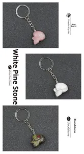 Three crystal skull keychains in rose quartz, white turquoise, and bloodstone gemstones