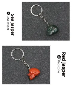 Detail of hand-carved ocean jasper and red jasper skull pendants on metal keychains