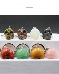 Detailed view of hand-carved 1-inch gemstone skulls with polished metal keychains