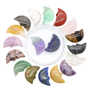 Carved moon-shaped natural crystal stones with human face engravings in various colors