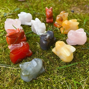 Figurines de lapins sculptées en pierres naturelles sur un lit de mousse verte