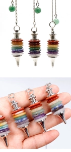 Close-up of a 7 Chakra natural crystal pendulum with a metal chain for meditation