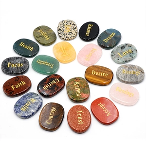 Macro shot of 20 engraved natural crystal stones with inspirational words on white background
