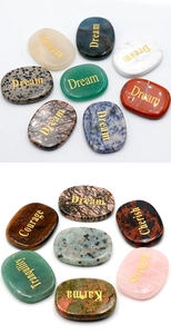 Detail of colorful natural healing stones with engraved inspirational gold text