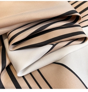 Detailed macro view of twill weave fabric and geometric print on a luxury square scarf