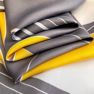 Detailed macro view of the twill texture and geometric pattern on a high-quality silk scarf