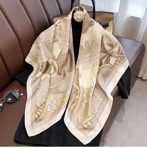 Detailed texture of silk-like floral square scarf draped on a black mannequin