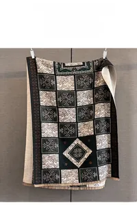 Detailed view of jacquard plaid pattern with retro geometric motifs and soft fringe trim