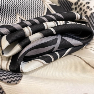 Detailed close-up showing the premium twill texture and geometric floral print of the silk scarf
