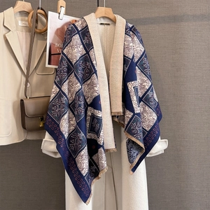 Detail of navy blue and beige checkered pashmina shawl with fringes over a white coat