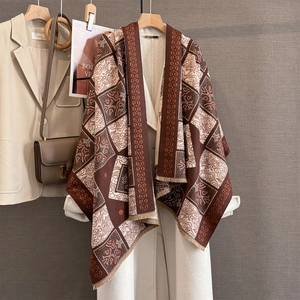 Detail of vintage geometric jacquard pattern and soft tassels on brown cashmere-feel shawl