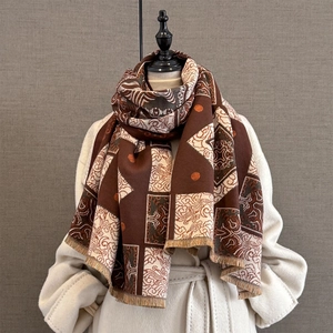 Retro brown cashmere-feel scarf with geometric patterns and fringe on white coat
