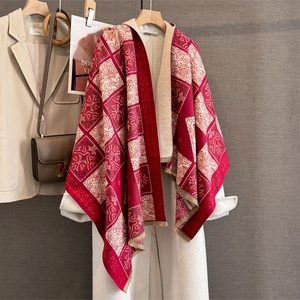 Detail of red and beige vintage check scarf with floral motifs and tassel edges