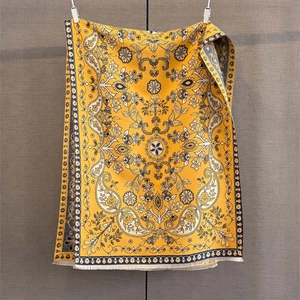 Détail d'une écharpe jacquard jaune à motifs paisley bleus et finitions à franges