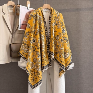 Détail d'une écharpe en cachemire jaune avec motifs paisley et fleurs en jacquard
