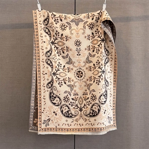 Détail du motif paisley jacquard et des franges douces sur une écharpe en cachemire