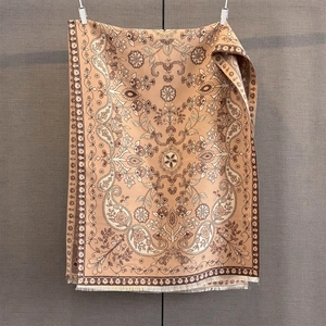Détails du motif paisley et franges sur un châle en cachemire de couleur marron