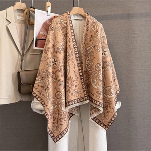 Détail d'un châle pashmina à motif paisley et franges porté avec un costume beige chic