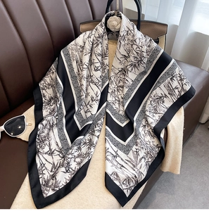 Detail of silk-feel square scarf featuring elegant black and white bamboo leaf patterns