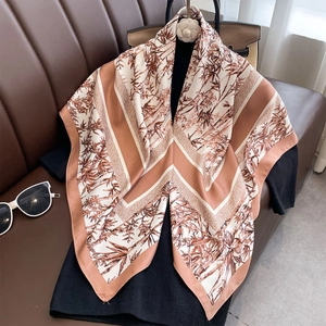 Classic silk satin square scarf with bamboo leaf print and caramel border on black knitwear
