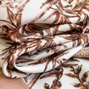 Macro shot of bamboo leaf print on silk scarf with elegant twill texture and soft drape