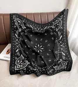 Detailtextur eines schwarz-weißen Paisley-Schals, der über ein Ledersofa fällt