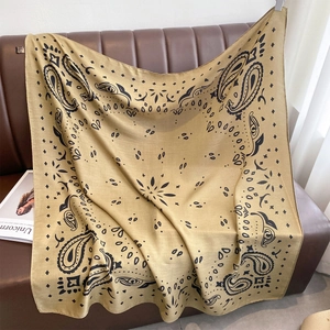 Großes senfgelbes quadratisches Tuch mit Paisley-Muster auf einem Ledersofa drapiert