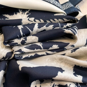 Macro detail of navy and cream botanical print silk scarf showing fine twill weave texture