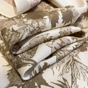 Detail of vintage floral print on silk-like satin fabric with elegant drape and texture