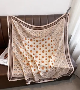 Detail of elegant floral print scarf in beige and orange on premium leather background