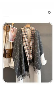 Detailed close-up of gray and orange plaid imitation cashmere scarf with letter B and tassels