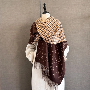 Close-up of cashmere-style shawl featuring letter B jacquard and fringe edges