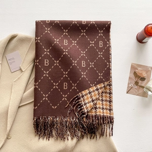 Detail of soft cashmere scarf with letter B pattern, houndstooth reverse and fringe