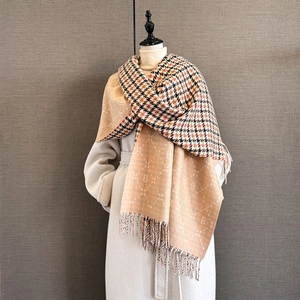 Detail of pashmina scarf featuring houndstooth pattern, letter B jacquard, and long tassels